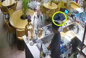 Stopklatka z monitoringu restauracji przedstawia mężczyznę stojącego przy bufecie i drugiego stojącego za bufetem.