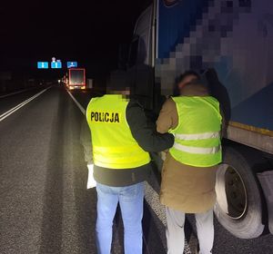 policjant idzie z zatrzymanym.