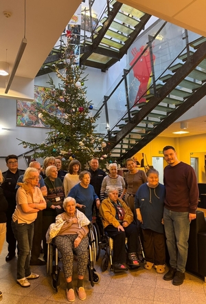 Policjanci z Biura Prewencji KGP podczas spotkania z podopiecznymi Centrum Alzheimera w Warszawie, w tle choinka świąteczna.