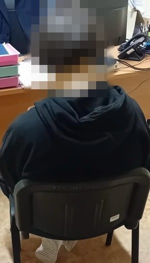 zatrzymany siedzi na krześle.