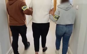 Dwoje nieumundurowanych policjantów prowadzi zatrzymanego.