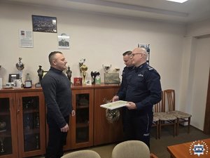 Policjanci wręczają podziękowania.