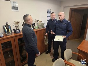 Policjanci wręczają podziękowania.