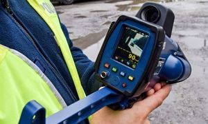 ręce policjanta. w rękach trzyma laser do pomiaru prędkości.