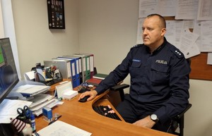 Umundurowany policjant przy biurku.