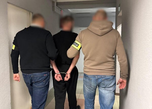 Zatrzymany prowadzony przez policjantów.