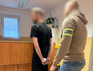 Policjant z zatrzymanym mężczyzną.