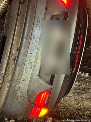 Uszkodzony w wypadku pojazd leżący na boku.