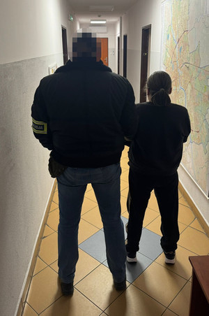 policjant stoi z zatrzymaną.