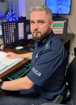 Umundurowany policjant przy biurku.