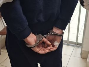 mężczyzna w kajdankach na posterunku.