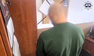 mężczyzna zatrzymany na komisariacie Policji, mężczyzna w kajdankach