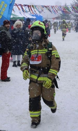 policjantka w kombinezonie strażackim przekracza metę.