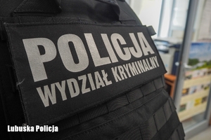 Kamizelka, a na niej napis: Policja, Wydział kryminalistyki.