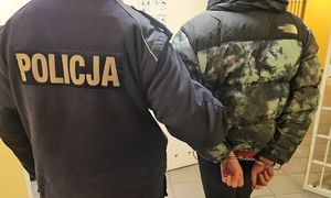 policja prowadzi w kajdankach sprawcę.