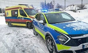 radiowóz policyjny i karateka pogotowia stoją na oblodzonej jezdni.