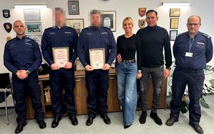 Policjanci, którzy otrzymali podziękowania, stoją w gabinecie z właścicielami restauracji.