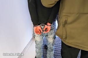 zatrzymany prowadzony w kajdankach.