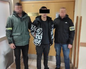 Dwaj nieumundurowani policjanci z zatrzymanym mężczyzną.