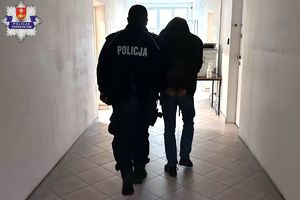 Policjanci prowadzą zatrzymanych.