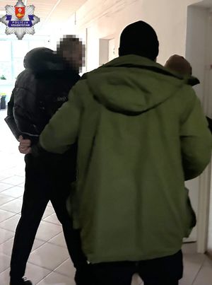 Policjanci prowadzą zatrzymanych.