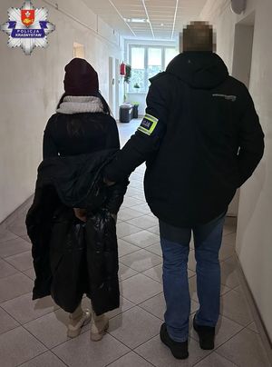 Policjanci prowadzą zatrzymanych.