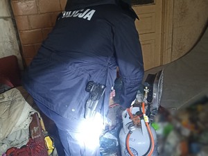 Policjant w mieszkaniu z butlą gazową.