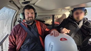 Ratownik medyczny i policyjny lotnik we wnętrzu śmigłowca z pojemnikiem z sercem.