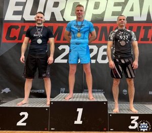 trzy osoby stoją na podium.