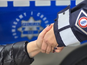 Policjant trzyma rękę kobiety.