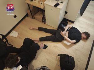 mężczyźni leżą na podłodze skuci kajdankami.