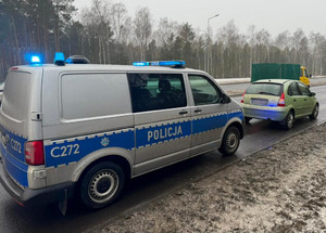 Policyjny radiowóz stojący za samochodem.