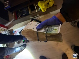 Trzymany w dłoni plik banknotów.