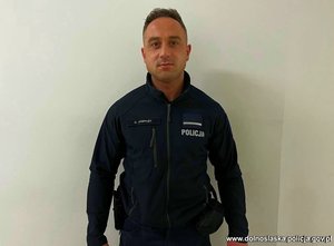 Policjant pozuje do zdjęcia.