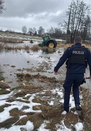 Policjant i ciągnik w rzece.