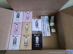 na podłodze rozłożone są kartony i worki z nielegalnym tytoniem, papierosami i odzieżą.