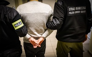 Funkcjonariusze prowadzą zatrzymanego.