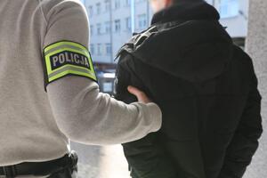 Policjanci prowadza zatrzymanego.