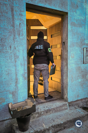 Funkcjonariusz CBZC wchodzi do budynku.