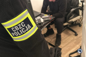 Funkcjonariusz CBZC siedzi przed ekranem komputera.