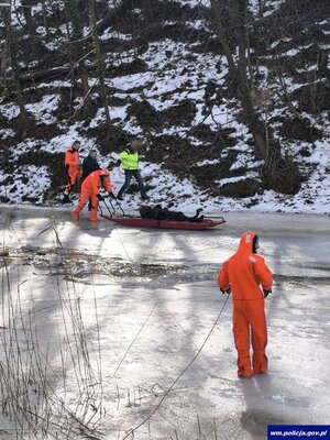 asp. szt. Paweł Kutryb oraz czterej inni mężczyźni podczas ratowania mężczyzny, który wpadł do rzeki.