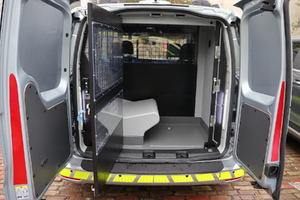 Zdjęcie przedstawia przestrzeń do przewozu osób zatrzymanych w samochodzie typu kombivan.