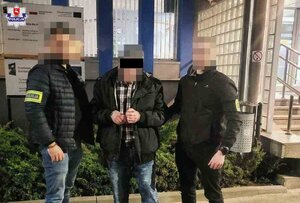 policjanci prowadzą skutego kajdankami mężczyznę.