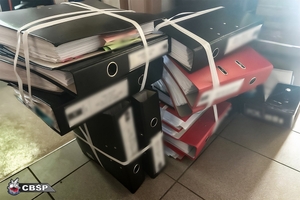 Zabezpieczone przez policjantów segregatory z dokumentami.