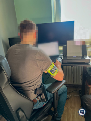 Funkcjonariusze podczas zabezpieczania sprzętu informatycznego.