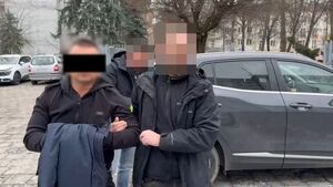 Policjanci prowadzą zatrzymanego.