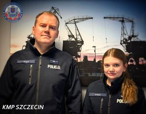 Policjantka i policjant stoją na tle ściany, na której wisi grafika z widokiem na Port w Szczecinie.