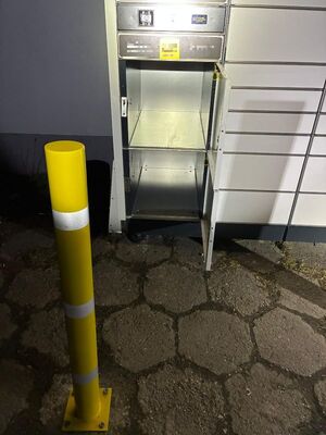 Paczkomat z otwartymi dolnymi skrytkami.