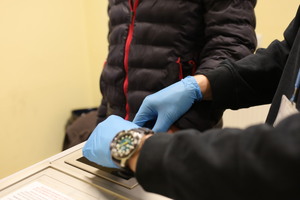 Policjant pobiera odciski palców od zatrzymanego.
