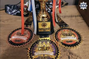 Trzy medale i fragment pucharu.